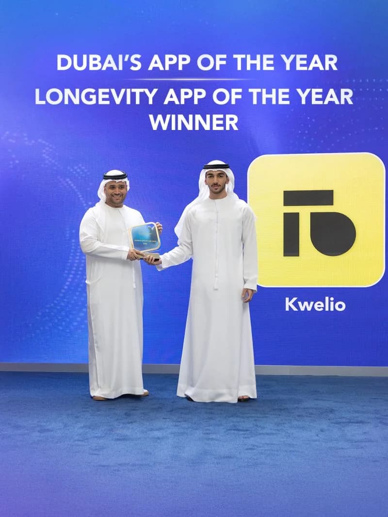 Dubai's App of the Year 2026 trophy presented to Kwelio on stage, under a screen reading Dubai's App of the Year, Longevity App of the Year, Winner, beside the Kwelio logo